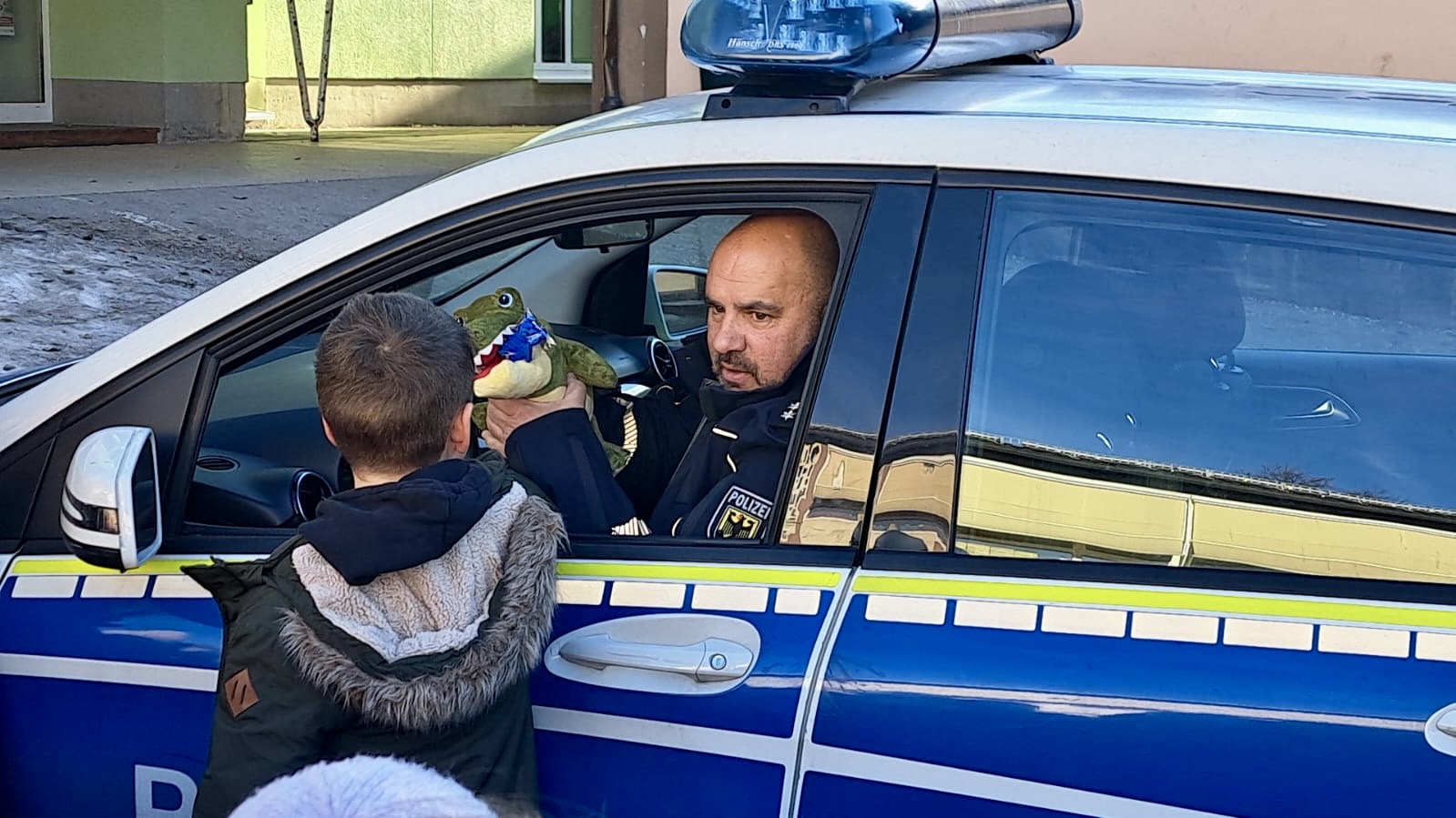 Kinder mit Bundespolizist am Polizeifahrzeug